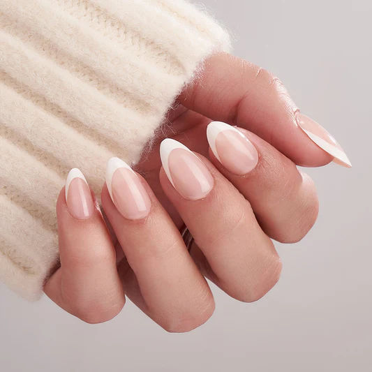 Exemplo de uma das tendências em alongamentos de unhas citadas neste post, conhecida como french moderno, unhas em tamanho curto porém com formato em stiletto e com uma paleta de cores em dois tons de branco. 